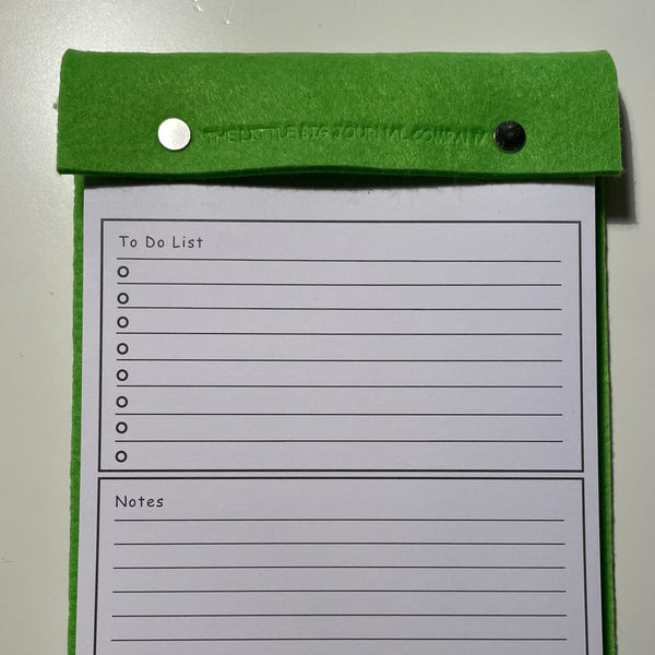 Bright green desk tear off notepad showing printing on the pages