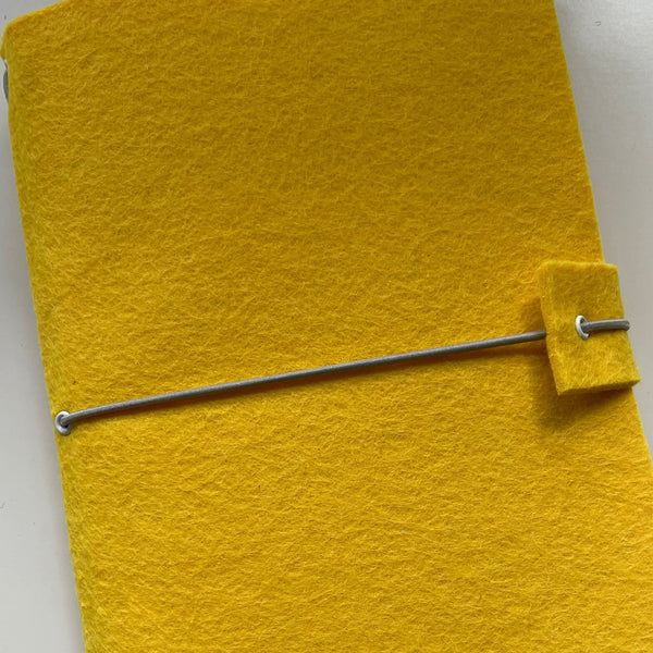 Felt journal handmade close up showing elastic strap which holds everything together