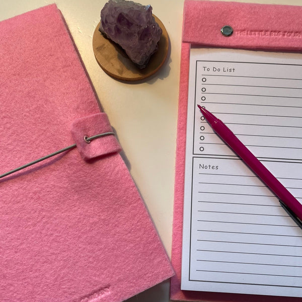 Pink felt wrap A5 refillable journal with elastic strap holding notebooks inside and a pink felt covered notepad with tear off pages for a to do list