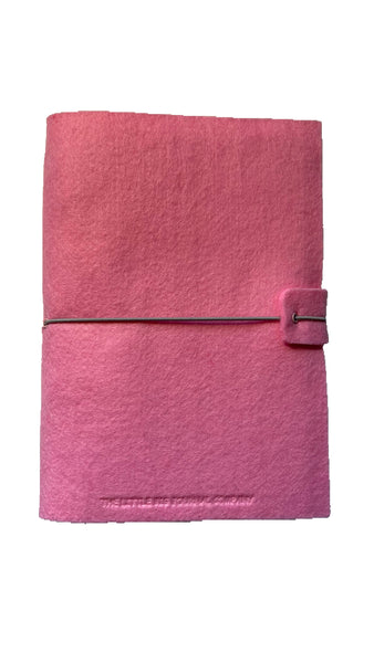 Pink felt wrap A5 refillable journal with elastic strap holding notebooks inside 