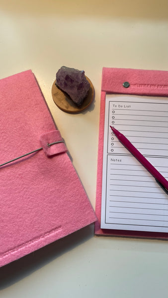 Pink felt wrap A5 refillable journal with elastic strap holding notebooks inside and a pink felt covered notepad with tear off pages for a to do list