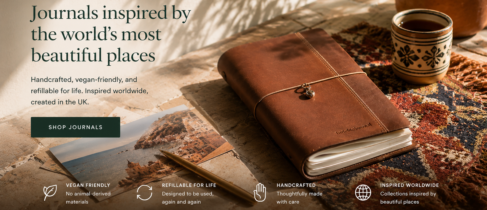 Brown leather journal on a textured surface with a cup and plant, text about journals inspired by beautiful places.