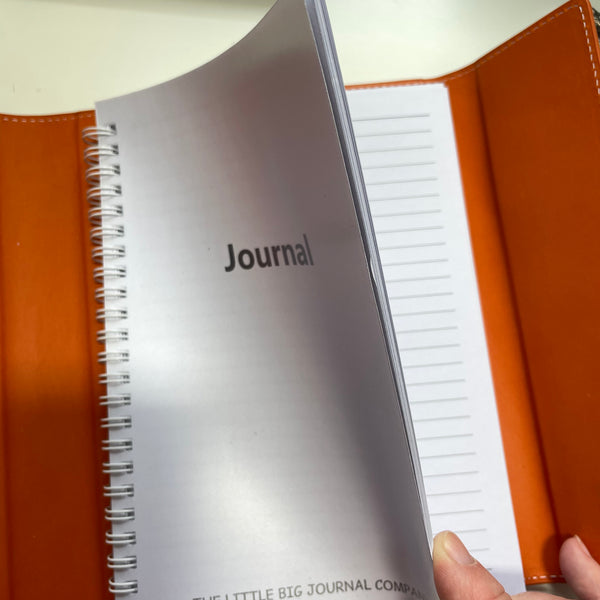 burnt orange faux leather refillable journal showing the lined pages on the refillable insert
