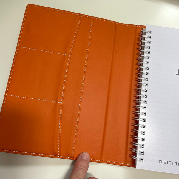 burnt orange faux leather refillable journal shown open with the front pockets on display