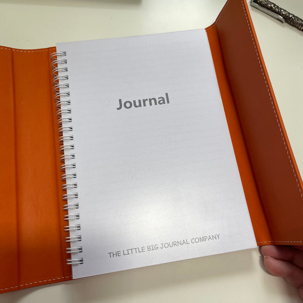 burnt orange faux leather refillable journal shown open with the lined papers insert on show
